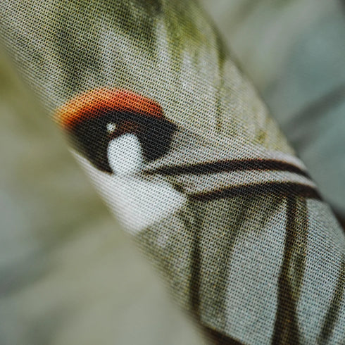 Close-up of a fabric with embroidered bird design on a blurred background